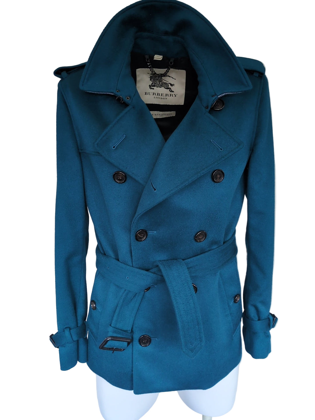 Blue coat on a white surface with a visible brand label.