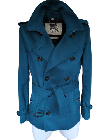 Blue coat on a white surface with a visible brand label.